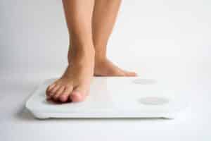 Woman checking weight after vein issues in Port Jefferson, NY